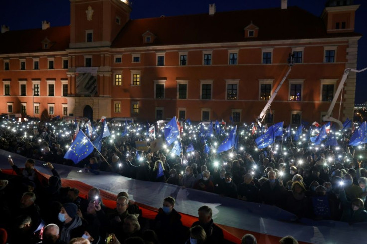 In Warsaw, protesters lit up a central square with their mobile phones, sang the national anthem and chanted 'We're staying!'