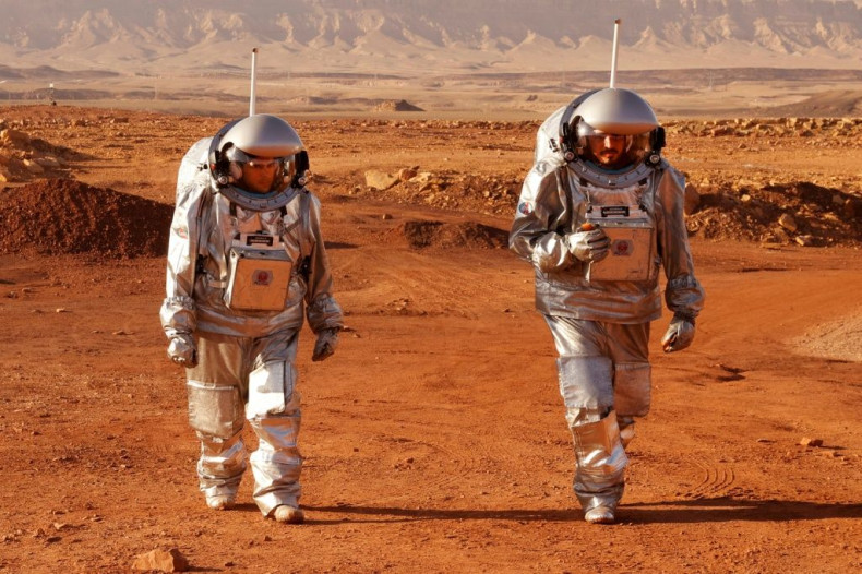 A couple of trainee astronauts walk in their spacesuits during a training mission for planet Mars inside the Ramon Crater in Mitzpe Ramon in Israel's southern Negev desert