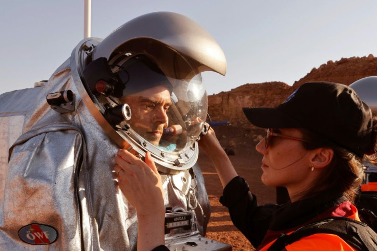 Technicians assist a trainee astronaut to suit up in a spacesuit. Six members from Portugal, Spain, Germany, the Netherlands, Austria and Israel will be cut off from the world for a month