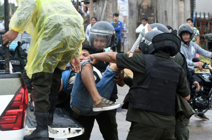 Riot police detain a man during a demonstration against the Bolivian government in Santa Cruz, on October 11, 2021.