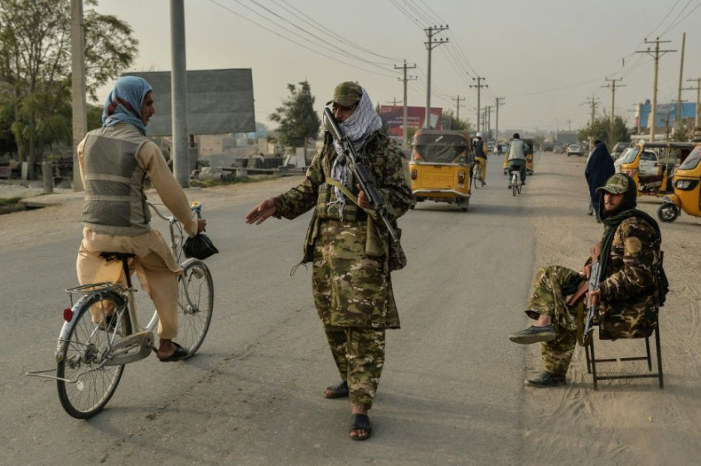 Taliban fighters check commuters along a road in Kunduz on October 10