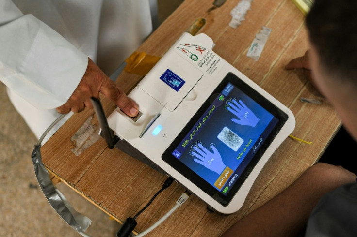 A voter scans his fingerprint Sunday while registering his vote at a polling station in the southern city of Nasiriyah