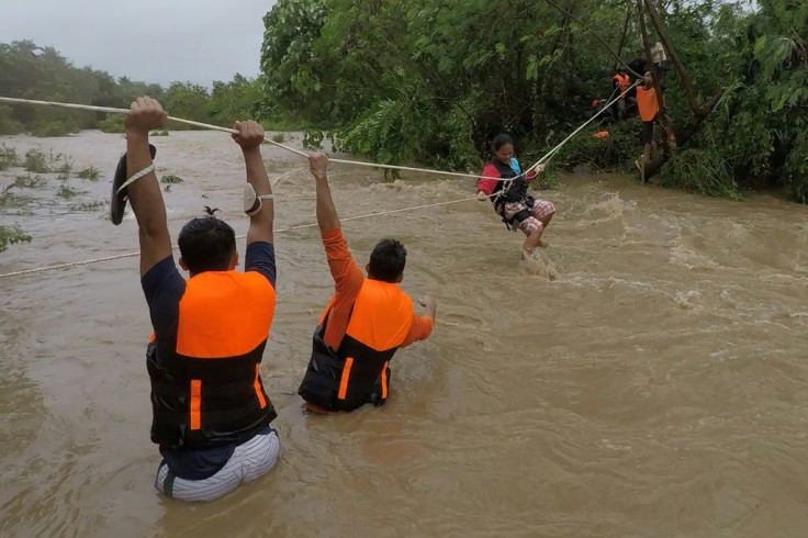 Rescuers evacuate residents from their homes near a swollen river due to heavy rains in Gonzaga town, Cagayan province, north of Manila