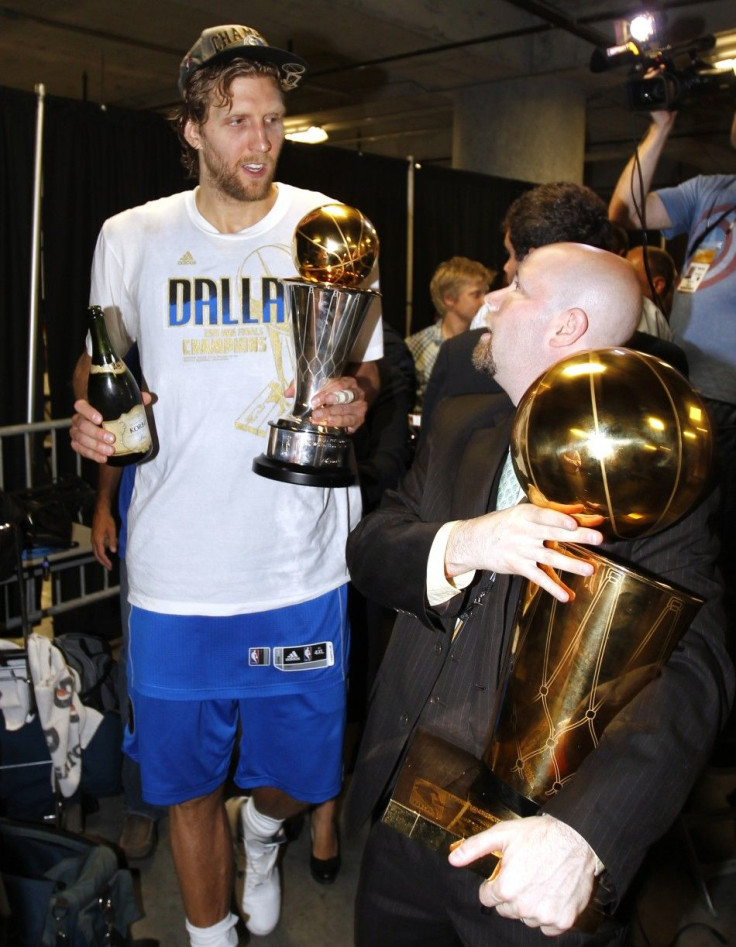 Dallas Mavericks Dirk Nowitzki walks with his MVP trophy and a bottle of champagne after the Mavericks won the NBA Championship defeating the Miami Heat in Miami