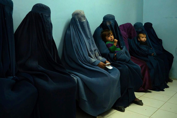 Burqa-clad women with children inside the Tangi Saidan clinic