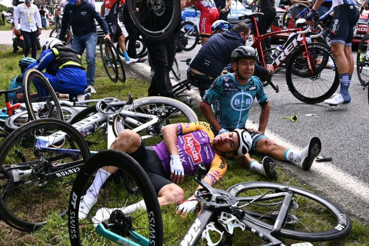 Dozens of Tour de France riders fell after one clipped a sign brandished by a spectator