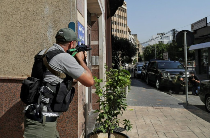 A fighter of the Shiite Amal movement takes aim during clashes in Tayouneh in Beirut's southern suburbs