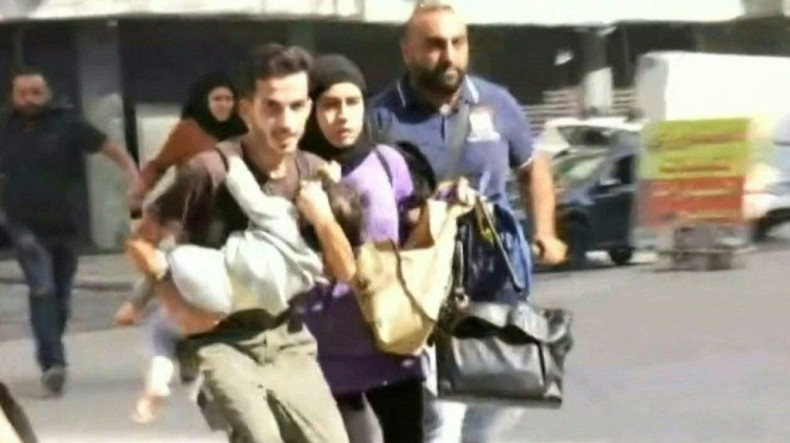 IMAGES  A family runs holding their child as they flee the Tayouneh neighbourhood of Beirut during intensive gunfire clashes that broke out following a Beirut rally organised by the Shiite Hezbollah and Amal movements to demand the dismissal of the lead i