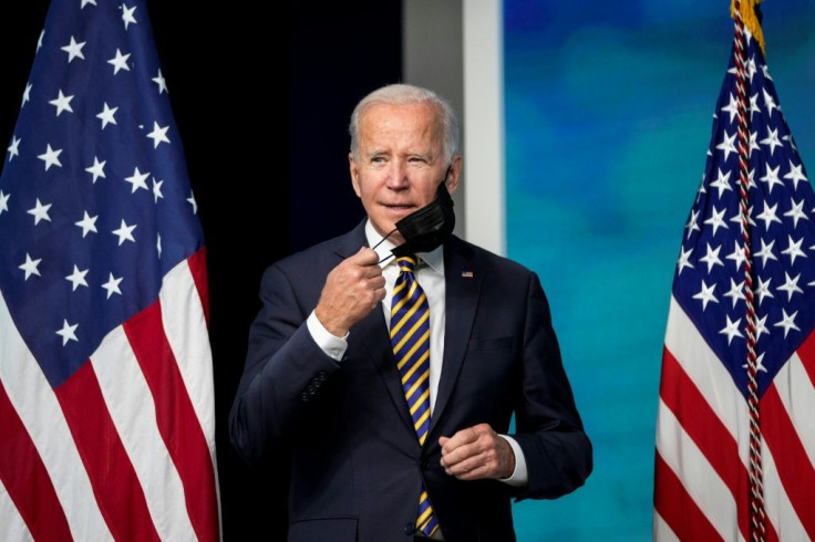 President Joe Biden signed into law a bill to lift the nation's borrowing authority, averting the threat of a first-ever debt default -- but only for a few weeksremoves his face mask as he arrives to speak in the South Court Auditorium on the White Hous