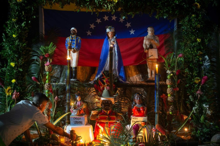 A man lights a candle on an altar to the Maria Lionza goddess on the Sorte mountain in Venezuela