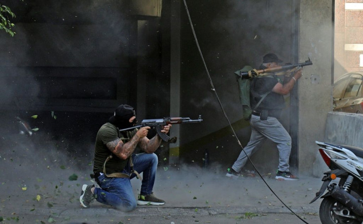 Fighters from the Shiite Amal and Hezbollah movements take aim with an assault rifle and rocket-propelled grenade during Thursday's clashes in the Lebanese capital