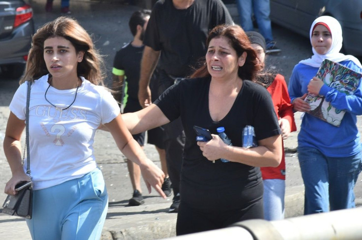 Civilians run for cover during the unrest in Beirut that left dead six people