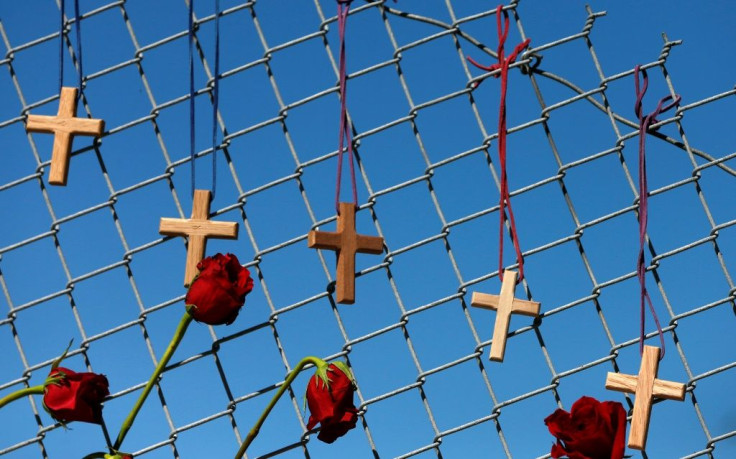 Flowers and crosses hang on a fence in memory for the victims of the Marjory Stoneman Douglas High School shooting