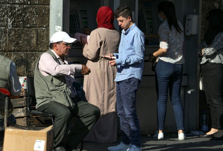 Palestinian men exchange currencies in the West Bank city of Ramallah; the local  shekel surplus has seen its value fall against major global currencies