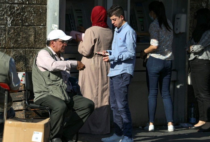 Palestinian men exchange currencies in the West Bank city of Ramallah; the local shekel surplus has seen its value fall against major global currencies