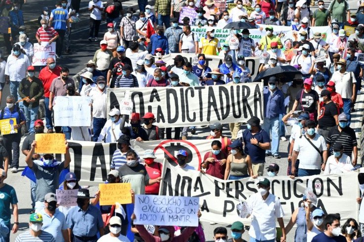 People take part in a demonstration against the circulation of Bitcoin and other economic measures, as well as a decree that removed judges from their functions, in San Salvador, on October 17, 2021