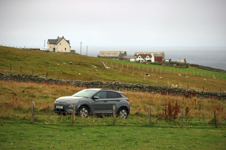 Fiona Nicholson charges her car using a charge point located on the shore of Bluemull Sound supplied by a tidal energy source