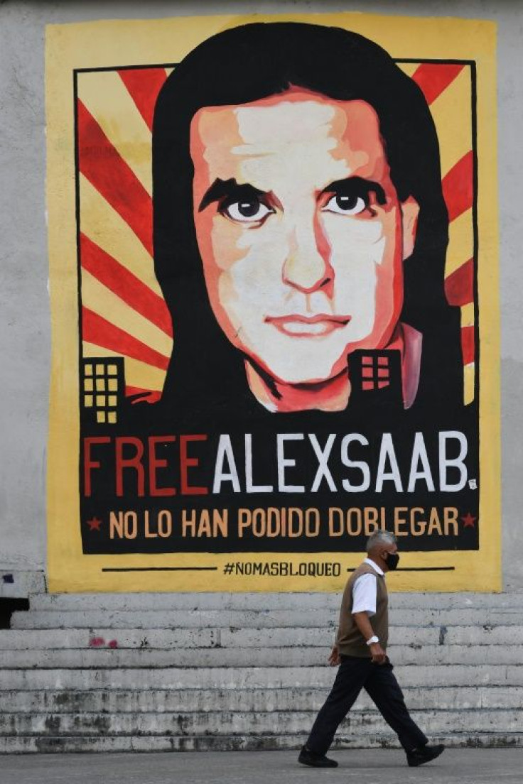 A man walks past a poster demanding the freedom of Colombian businessman Alexander Saab, who was extradited to the United States, in Caracas, on October 17, 2021