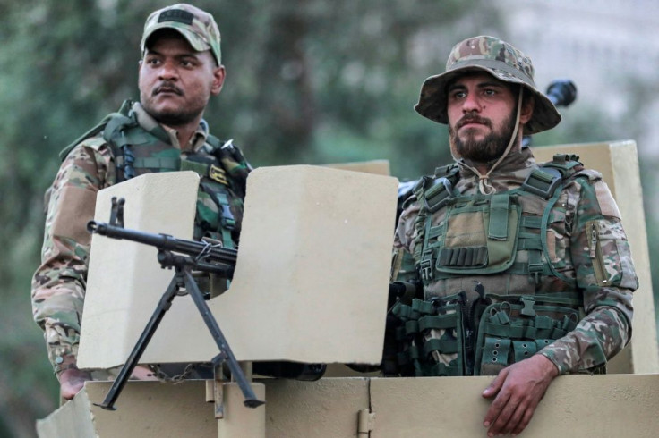Members of Iraq's Hashed al-Shaabi stand guard during an election rally