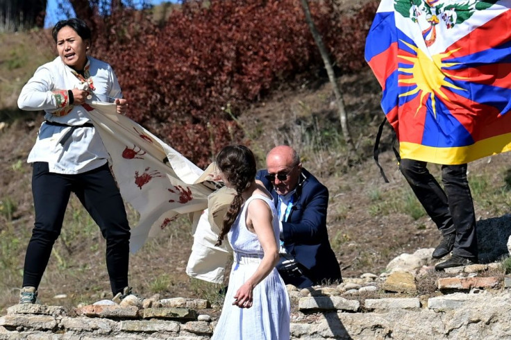 A security officer tried to stop protesters holding a banner and a Tibetan flag at the flame-lighting ceremony for the 2022 Beijing Winter Olympics