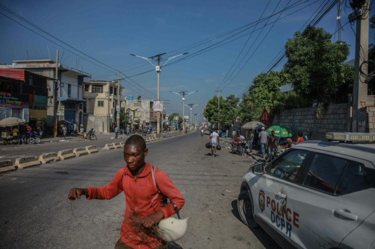 People walk on a road following a call for a general strike in Port-au-Prince on October 18, 2021