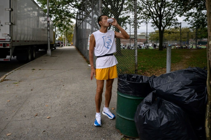 Lo Wei Ming of Taiwan stops for a drink during the world's longest certified foot race, in the Queens borough of New York on October 12, 2021