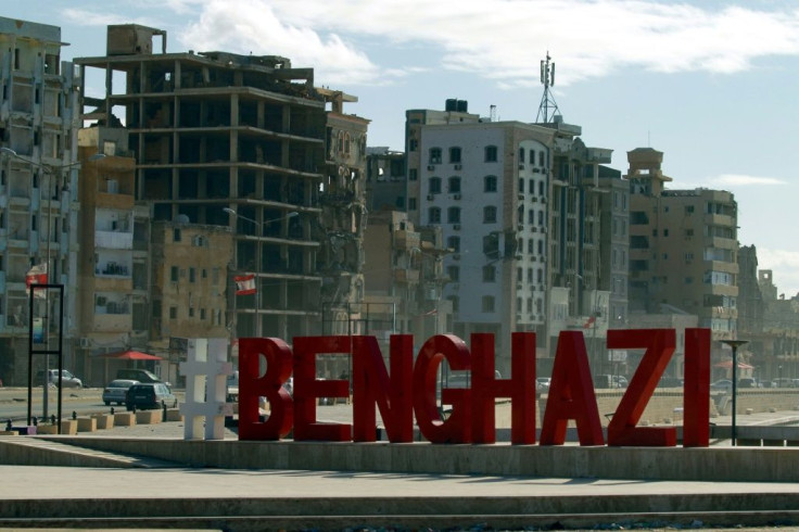 A city name sign is pictured in front of war-ravaged buildings in Libya's eastern city of Benghazi
