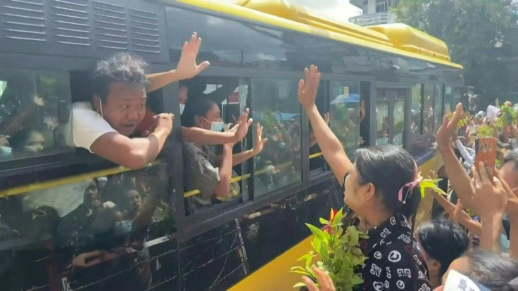 Freed pro-democracy protesters wave as they are transported out of a prison in Myanmar's Yangon.Family members crowded outside the prison on Tuesday, hoping their relatives would be among thousands the junta has promised to release as it faces growing i