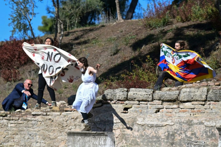 Protestors holding the Tibetan flag and a banner crash the flame lighting ceremony for the Beijing 2022 Winter Olympics