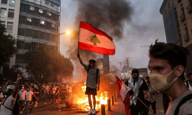 A protester holds a flag during clashes with armed forces in Lebanon, whose economy is in a tailspin