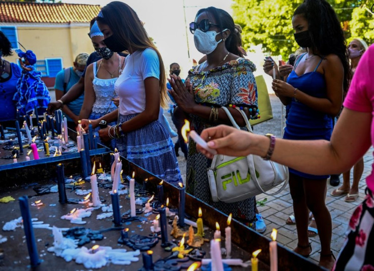 Mayda Yudith Sotolongo (c) prays for the release of her son Yunior Consuegra, who was arrested during street protests on July 11 against the Cuban government