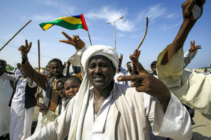 Beja people raise the flag of the Beja Congress political group as they demonstrate outside the Osman Digna port