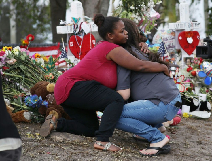 Elizabeth Smith (L) and Lindsey Riha, teachers at Marjory Stoneman Douglas High School, hug each other as teachers and staff returned to the school for the first time since the mass shooting on campus