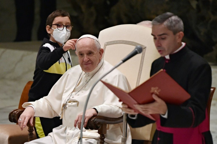 A boy makes clear he wants Pope Francis's cap during surprise appearance at Vatican audience