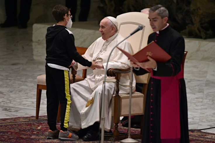 Pope Francis is greeted unexpectedly by a child during the weekly general audience in the Vatican on October 20, 2021