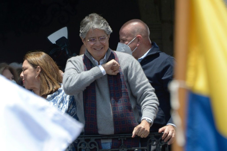 Ecuador's President Guillermo Lasso gestures to supporters who gathered outside the Carondelet presidential palace in Quito, on October 20, 2021. Lasso has refused to go to the opposition-dominated Congress to give his version of the scandal involving him