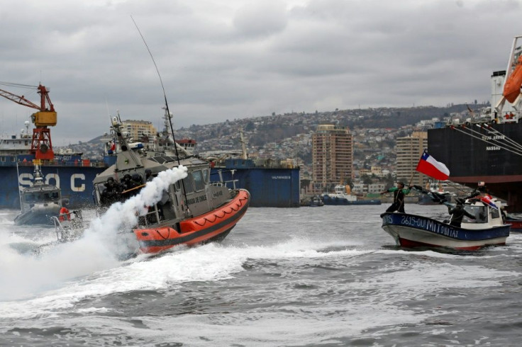 Maritime police shoot tear gas at a fishing boat protesting in the Port of Valparaiso, Chile