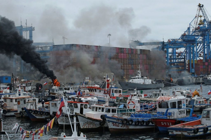 View of smoke as fishermen set tires on fire during a protest in the Port of Valparaiso, Chile