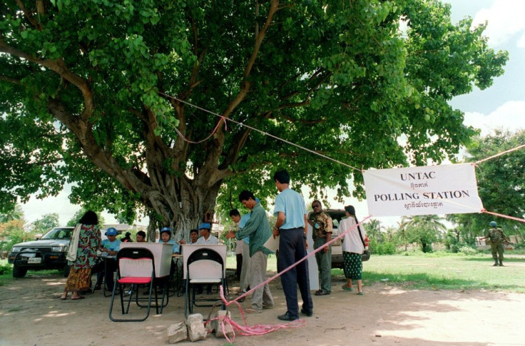 In this file photo taken in 1993, people wait to cast their ballots in the country's first democratic election at a mobile polling station in Phnom Penh