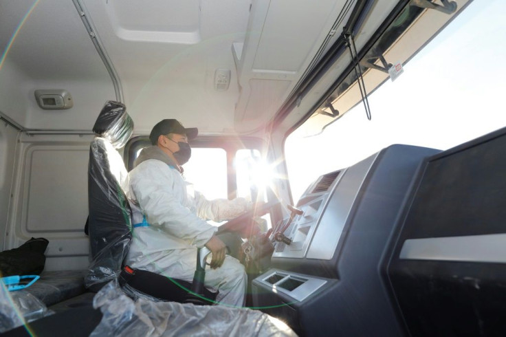 Drivers are tested for Covid-19 in Mongolia then bussed over the Chinese border in masks and hazmat suits, where they undergo yet another test