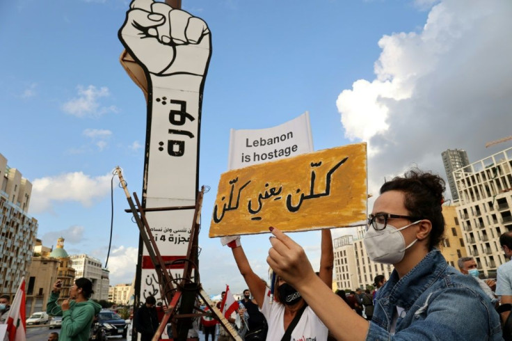 Protesters gather in central Beirut's Martyrs' Square on October 17, 2021 to mark two years since the start of the uprising. The small sign reads in Arabic: 'All of them, means all of them', a demand for the removal of Lebanon's political leaders