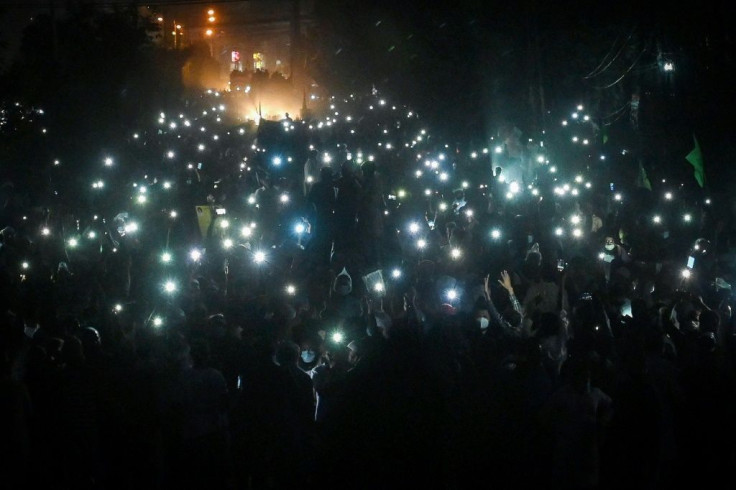 TLP supporters use mobile phone flashlights during their protest march towards Islamabad on Friday