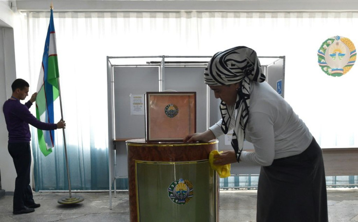 Local election commission members prepare a polling station for Sunday's presidential election in Tashkent