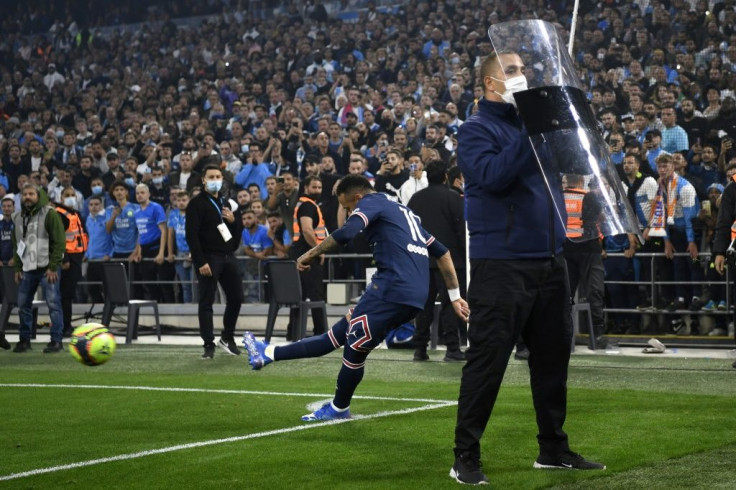 Neymar takes a corner as shields are held up to protect the Brazilian from objects raining down from the stands