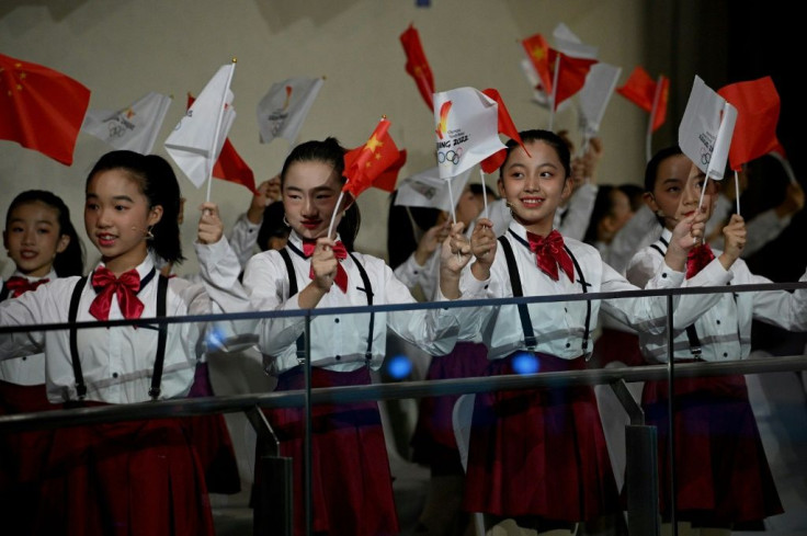 Children wave Chinese flags during the Olympic flame welcoming ceremony in Beijing