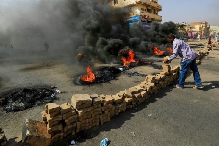 Sudanese protesters place bricks across a street in the capital Khartoum