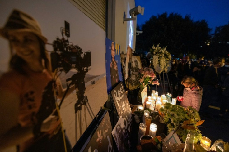 A girl pays respects near a photo of cinematographer Halyna Hutchins, at a memorial table during a candlelight vigil in her memory in Burbank, California on October 24, 2021