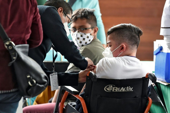 A minor in Mexico City is inoculated with the Pfizer-BioNtech vaccine against Covid-19 as part of the capital city's plan to vaccinate at-risk youths