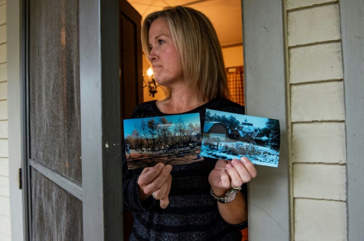 Jennifer Cashman holds photos of before and after the fire that destroyed her former home Paradise, California, on the front porch of her new rental home in Stowe, Vermont
