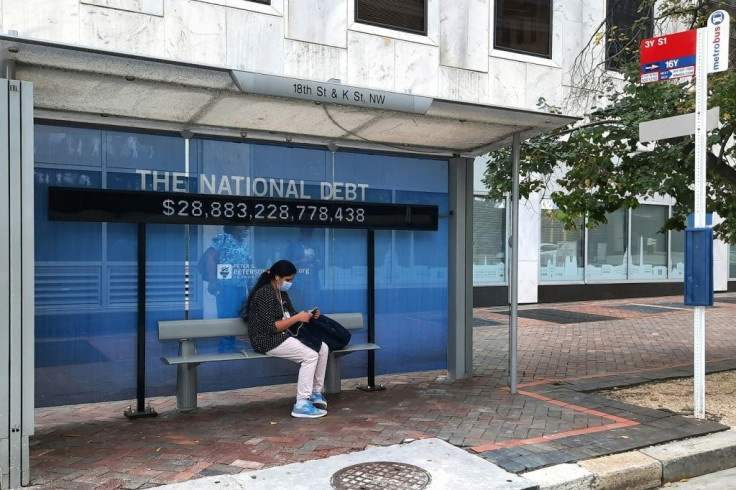 A sign at bus stop shows the amount of the US national debt in Washington on October 25, 2021